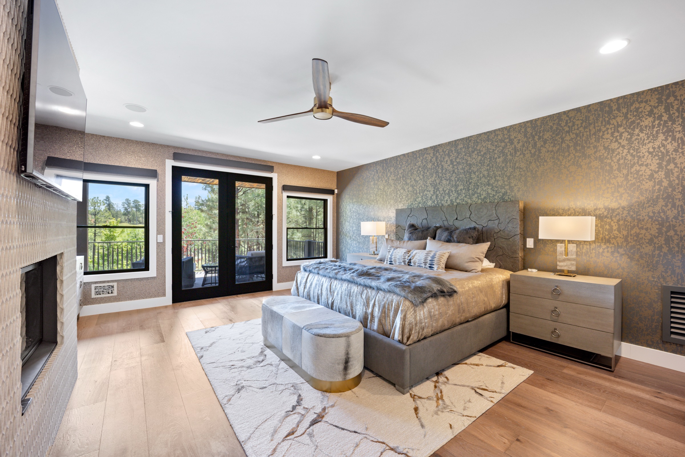 Primary bedroom with metallic wallcovering and carved headboard