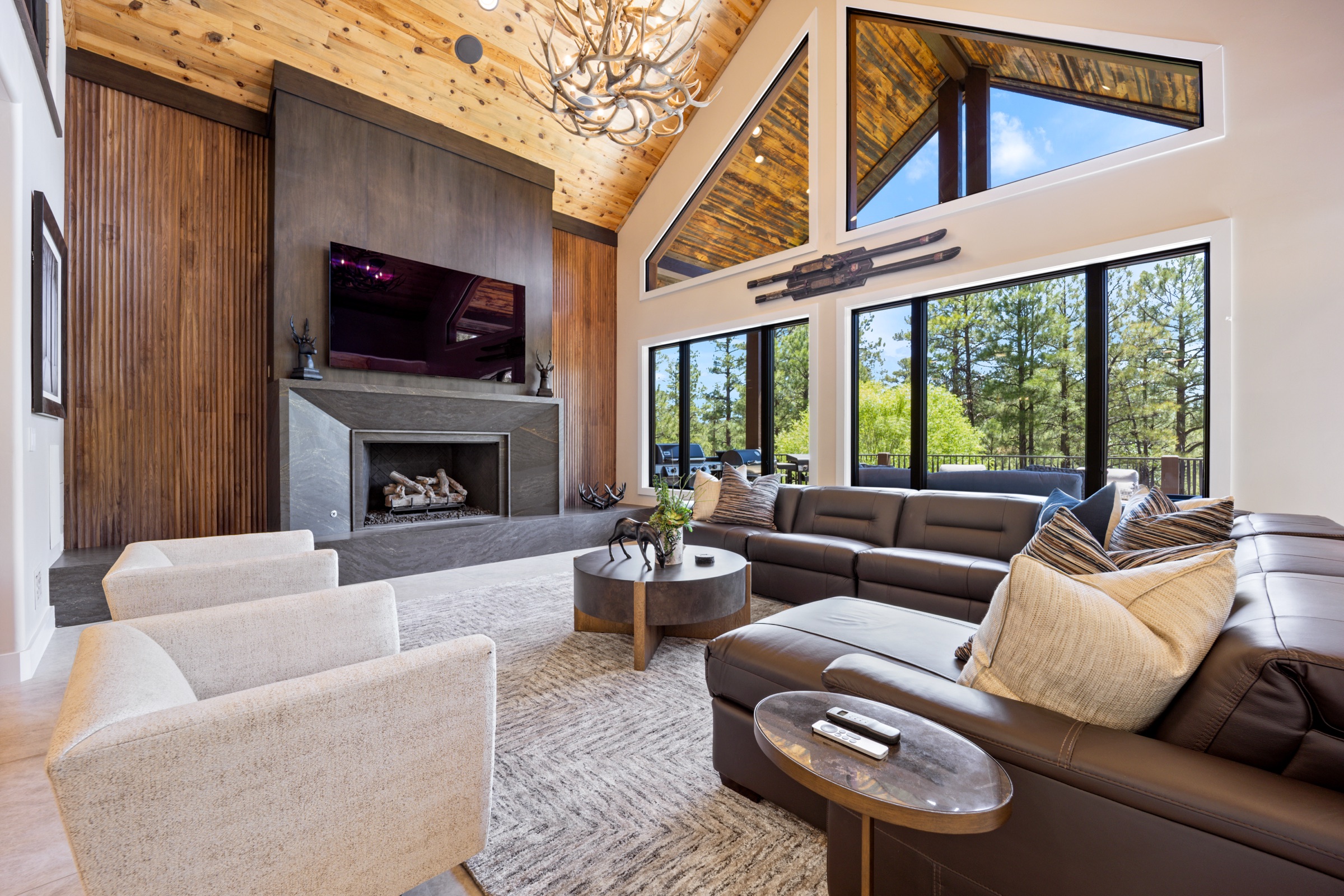 Great room with vaulted wood ceiling, stone fireplace and antler chandelier