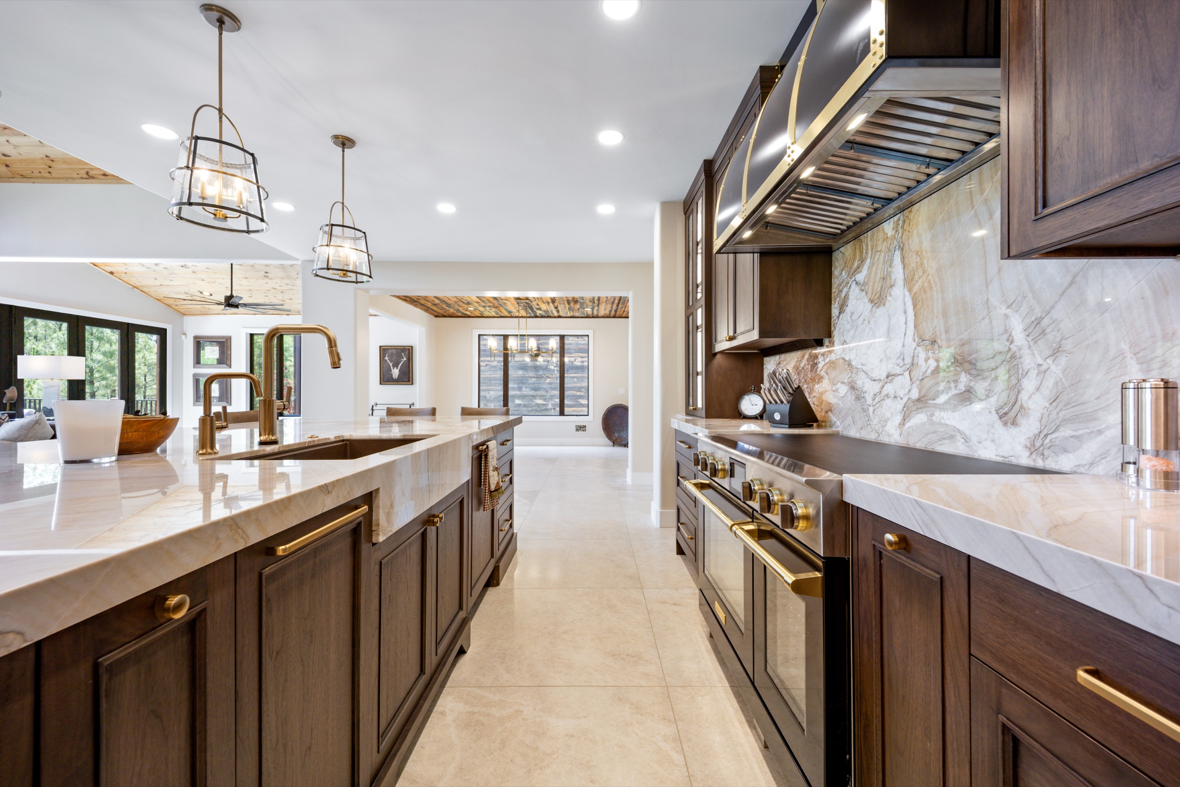 Kitchen range wall with quartzite backsplash and brass-trimmed hood